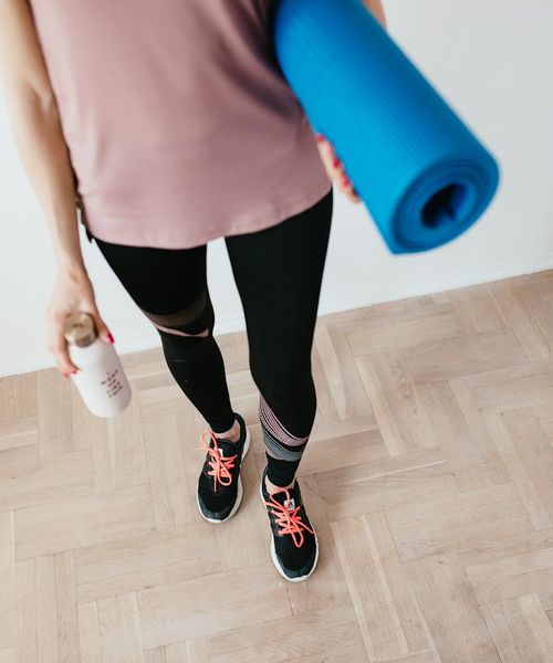 Yoga mat and water bottle in a calm, prepared space.